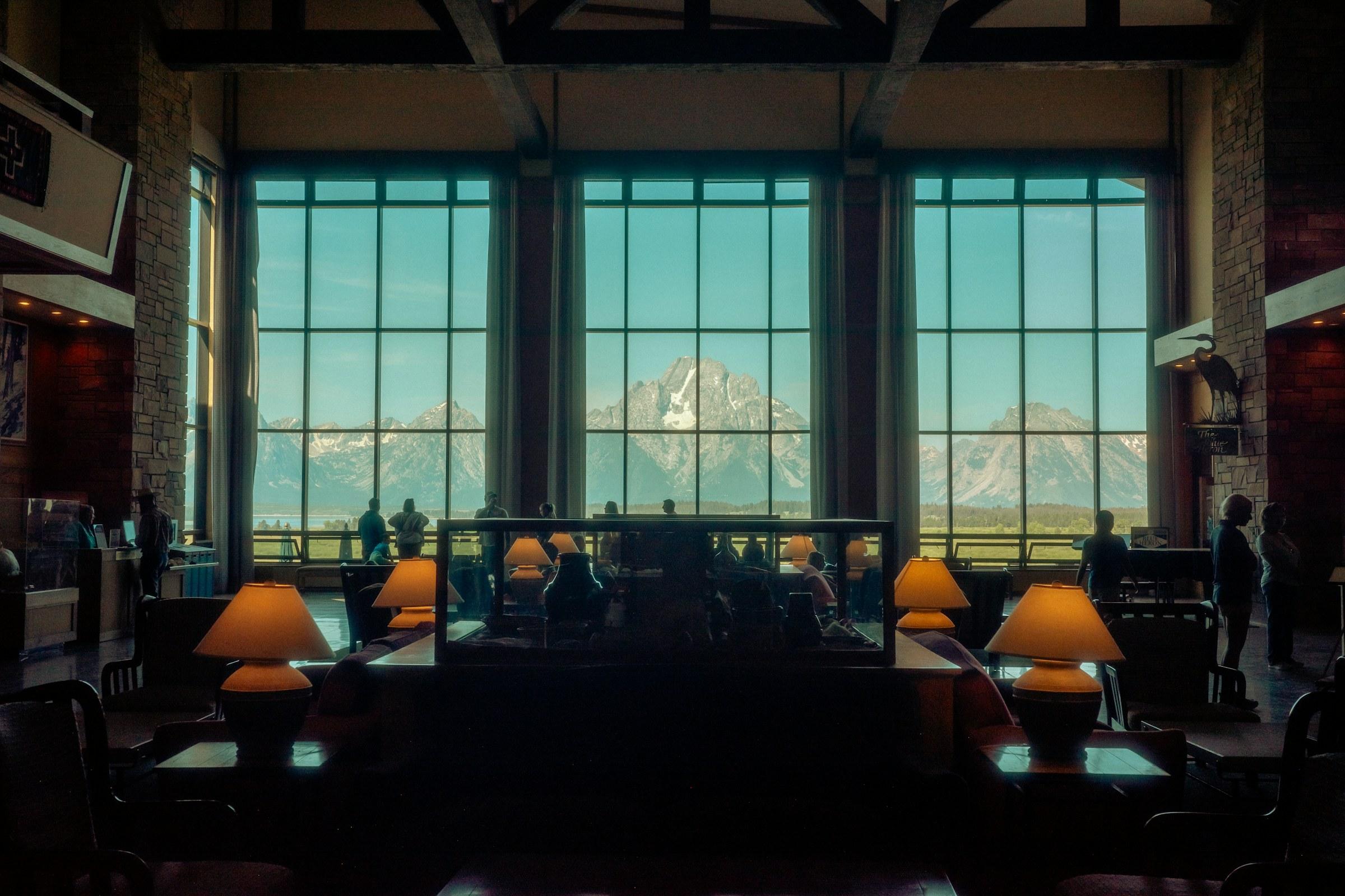 Salón de restaurante con lámparas cálidas y ventanal con vista a la montaña